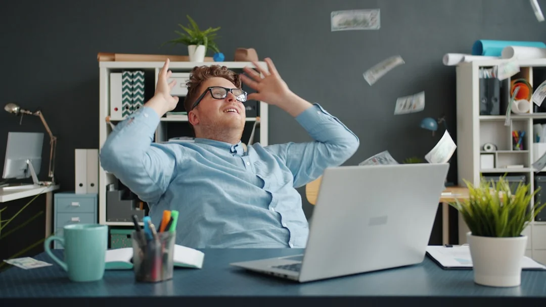 A modern workspace showing hands analyzing marketing data on a laptop and paper documents.